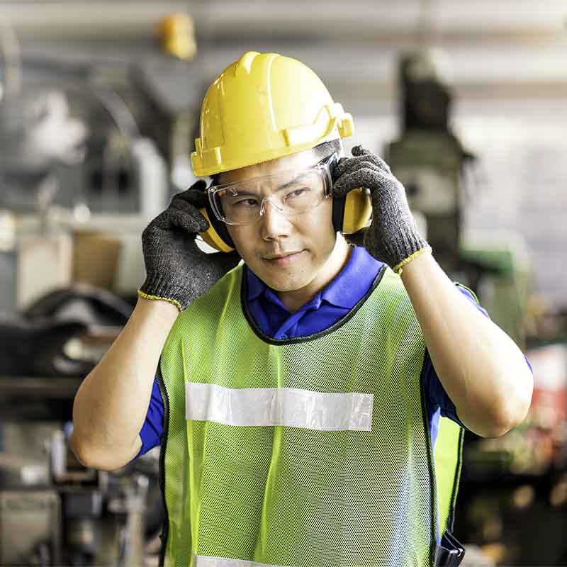 Factory worker wearing hearing protection. 